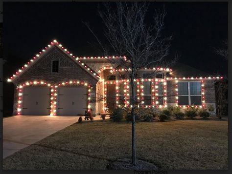 Brick home with multicolored roofline lights