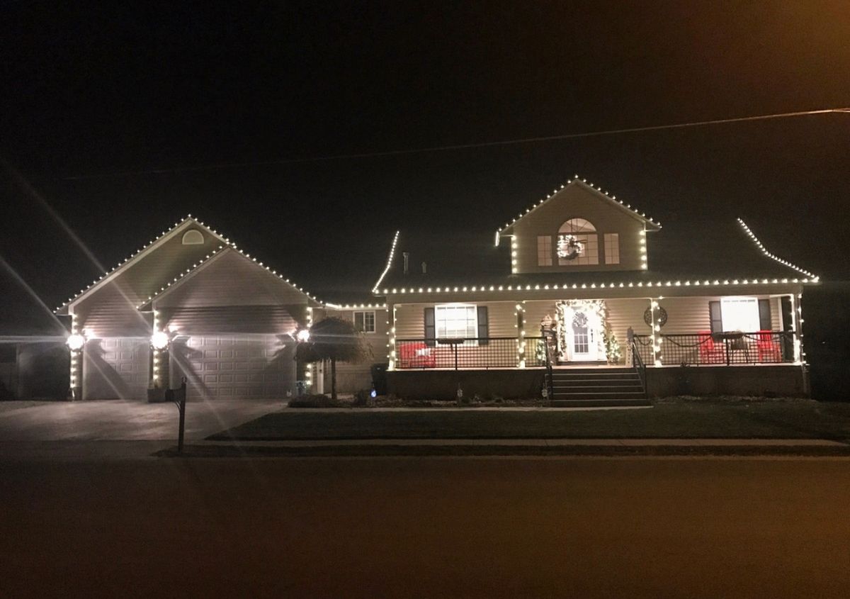 Large two-story house with white lights and front porch